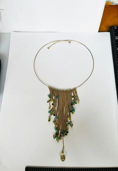 This wire Choker is Vintage. It has been worn. It was made in approximately the 1990s. The beads dangle beautifully.  The colors are gray, green and shades of blue. Any questions please message me.  The necklace will arrive in a gift box. Green Bohemian Metal Beaded Necklaces, Adjustable Green Beaded Chain Turquoise Necklace, Bohemian Green Jewelry With Beaded Fringe, Green Bohemian Beaded Metal Necklace, Bohemian Green Beaded Metal Necklace, Green Bohemian Dangle Turquoise Necklace, Bohemian Green Turquoise Dangle Necklace, Wire Choker, Vintage Rhinestone Necklace