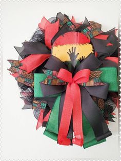 the wreath is decorated with black, red and green ribbons