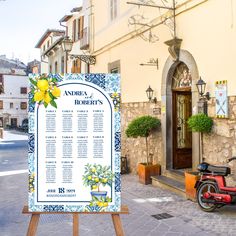 a sign is in front of a building with flowers and lemons on it, next to a scooter