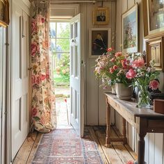 an entry way with flowers and pictures on the wall next to it's door