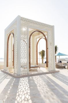 a white gazebo sitting on top of a sandy beach