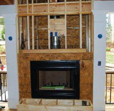 a living room with a fire place built into the wall and wooden framing around it