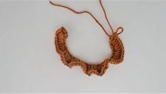 a crocheted necklace is shown on a white surface