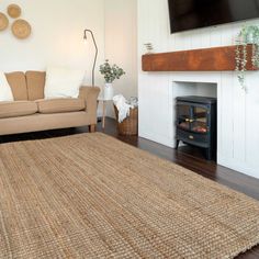 a living room with a couch, fireplace and television mounted on the wall above it