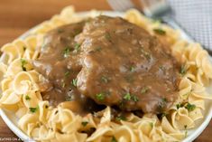 a white plate topped with pasta and gravy covered in gravy sauce