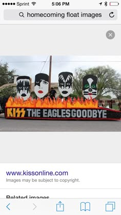 an iphone screenshot of a sign that reads kiss the eagles goodbye and has flames in front of it