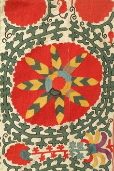 an intricately designed rug with flowers and vines on the side, in red and green colors