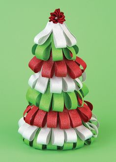 a small christmas tree made out of ribbon on a green background with red and white bows