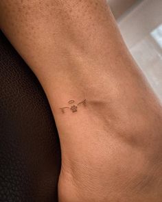 a person's foot with a small tattoo on the left side of their leg