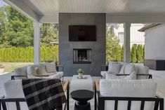 an outdoor living room with white furniture and fireplace