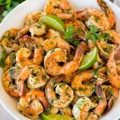 a white bowl filled with shrimp and lime