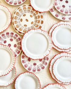 a table topped with lots of white and red plates