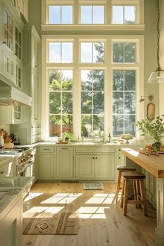 a kitchen filled with lots of green cabinets and counter top space next to a window