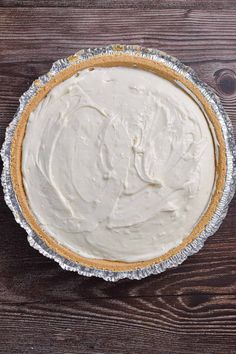 a pie with white frosting in a pan on a wooden table