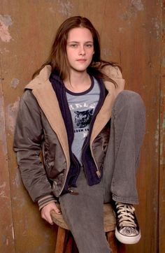 a young man sitting on top of a wooden stool