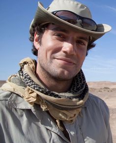 a man wearing a hat and scarf in the desert