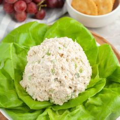 a plate with some food on it next to grapes and crackers