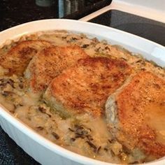 three pieces of chicken are in a white casserole dish on the stove top