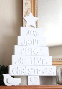 a white christmas tree sitting on top of a wooden shelf