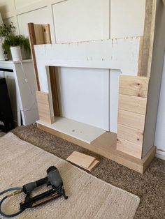 an unfinished fireplace being built in a living room with tools on the floor next to it