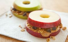 two apples with peanut butter and apple slices on them