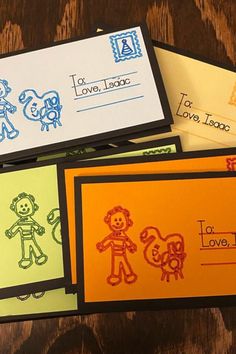 four different colored envelopes with children's drawings on them