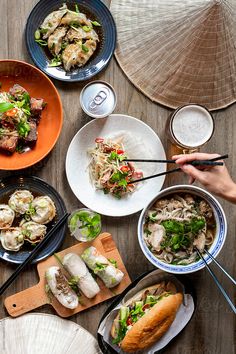 several plates and bowls of food on a table with chopsticks in each bowl