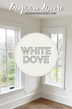 an empty room with the words white dove in front of two windows and a wood floor