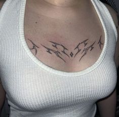 a woman wearing a white tank top with birds on her chest