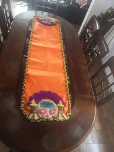 an orange table runner sitting on top of a wooden table