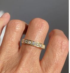 a person's hand with a gold ring on their left and the other hand holding an engagement ring