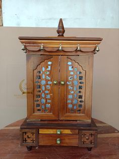 an old wooden cabinet with two doors on it's sides and drawers in the middle