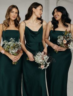 three bridesmaids in dark green dresses holding bouquets