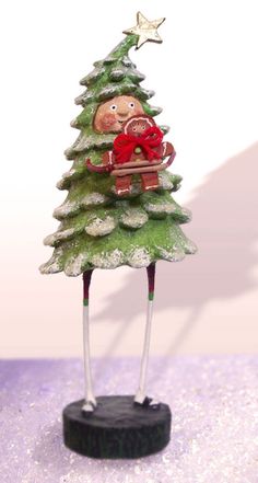 a small christmas tree with a person sitting on it