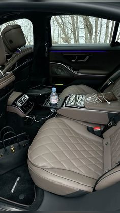 the interior of a car with an electronic device in the center console and leather seats