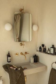 a bathroom with a sink, mirror and toiletries