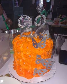 an orange and silver cake on a table