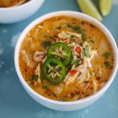 two white bowls filled with soup on top of a blue table