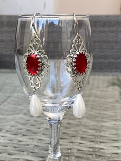 Gothic dangle earrings with tear drop pearls and red cabochon. Historical pearl drop earrings Materials used are Glass pearls, zinc alloy Centre cabochon is glass Measures as follows from top to bottom drop pearl 63mm including top pearl, excluding hooks Wrapped in gift box RETURNS EXCHANGES REFUNDS Returns, exchanges or refunds are accepted for may handmade jewellery pieces only from EU countries. Customer is responsible to pay for the return. Refund is for the cost of the product. For countrie Ornate Red Earrings For Party, Ornate Red Cabochon Jewelry, Ornate Red Drop Earrings, Red Cabochon Earrings For Wedding, Metal Chandelier Earrings With Pearl Drop As Gift, Red Elegant Nickel-free Teardrop Earrings, Victorian Teardrop Metal Jewelry, Teardrop Metal Pearl Earrings For Gift, Ornate Red Teardrop Jewelry