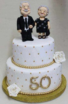 a 50th birthday cake with an older couple on top