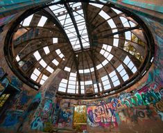 the inside of an abandoned building with graffiti all over it's walls and ceiling