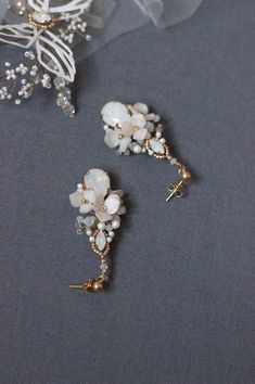 Wedding dangle floral earrings, Swarovski crystal and pearl rhinestone bridal earrings in white and gold color, Flower jewelry for bride A delicate Swarovski crystal and pearl earrings for wedding created of silver color Japanese Toho beads, Swarovski crystals and pearls, wired with silver color wire. 925 sterling silver earring studs. Measures about 0,98 by 1.97 inches /2.5 by 5 cm (at its widest part ). ♥100% handmade. ♥This item will be ready to ship within 5 business days (shipping time not White Crystal Flower Earrings For Party, White Pearl Cluster Earrings For Wedding, Delicate White Crystal Earrings For Party, White Pearl Embellished Wedding Earrings, White Dangle Pearl Earrings For Mother Of The Bride, Delicate White Pearl Bridal Earrings, Elegant White Crystal Flower Earrings, White Dangle Jewelry For Mother Of The Bride, Gold Crystal Flower Earrings For Wedding