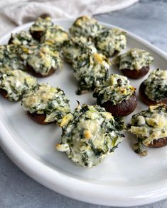 small stuffed mushrooms with spinach and cheese on a white plate