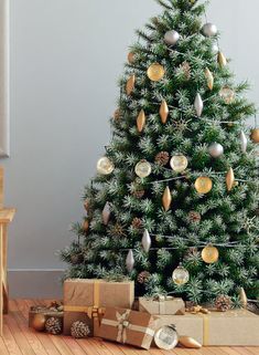 a christmas tree with presents under it and other decorations on the floor next to it