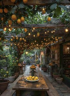 an outdoor dining area with lots of lemons on the table and lights hanging from the ceiling