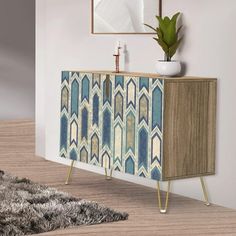 a white vase sitting on top of a wooden cabinet next to a rug and mirror