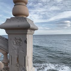 an old railing overlooking the ocean on a sunny day