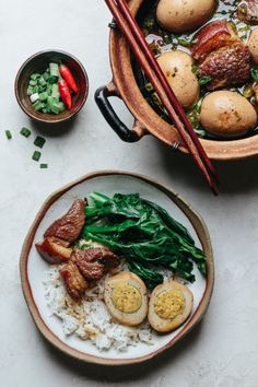 two bowls filled with food and chopsticks next to each other on a table