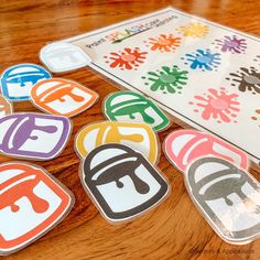 several different colored stickers sitting on top of a wooden table