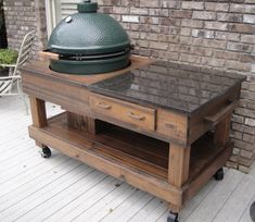 a big green egg sitting on top of a wooden cart